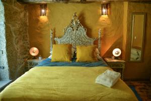 una camera da letto con un grande letto con cuscini gialli di Casa do Ti Gabriel a Sabugueiro