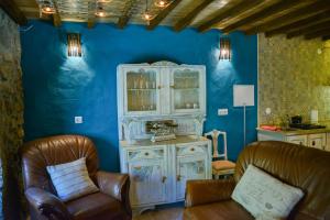 a living room with a cabinet and two chairs at Casa do Ti Gabriel in Sabugueiro
