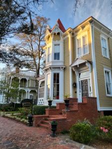 a yellow house with a brick staircase in front at Thomas Weihs Haus in Savannah