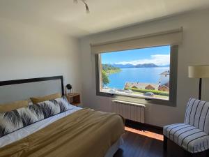 a bedroom with a large window with a view of a lake at Quinta Luna in San Carlos de Bariloche