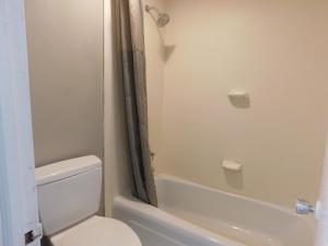 a bathroom with a toilet and a bath tub at Park View Inn. in Greensboro