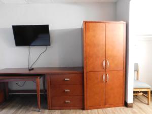 a desk and a cabinet with a television on top at Park View Inn. in Greensboro