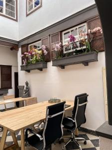 a dining room with a table and chairs and flowers on the wall at Gato Azul - Coliving in La Orotava