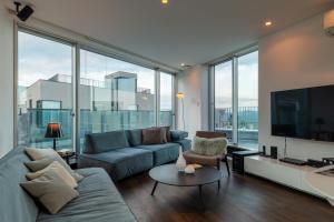 新雪谷的住宿－Kira Kira Suites by H2 Life，带沙发和平面电视的客厅