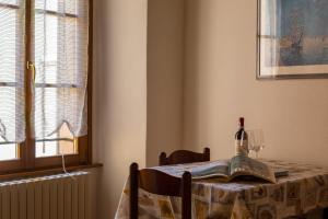 a table with a book and a bottle of wine at Appartamento Sant'Agostino in Tirano