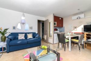 sala de estar con sofá azul y mesa en Air-Conditioned Apartment With Sea View Furnished Terrace & Parking en Cap d'Ail