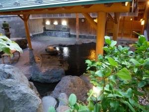 a pond under a pavilion in a garden at Yudanaka Tawaraya Ryokan in Yamanouchi