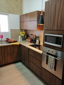 cocina con armarios de madera y microondas en Malecon Zone, en Puerto Vallarta