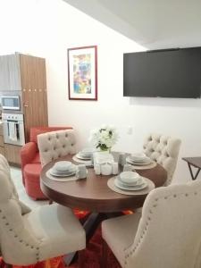 sala de estar con mesa de madera y sillas blancas en Malecon Zone, en Puerto Vallarta