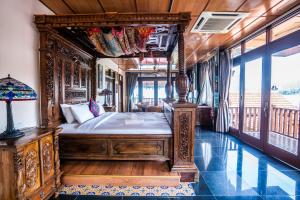 a bedroom with a wooden bed in a room with windows at Lost Paradise Resort in Batu Ferringhi