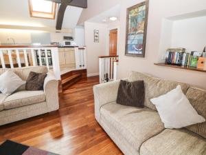 a living room with two couches and a kitchen at Horse Mill Lodge in Taddington