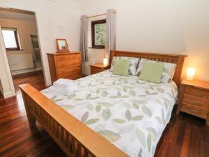 a bedroom with a large bed and two night stands at Horse Mill Lodge in Taddington