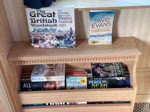 a book shelf with books on top of it at Orchard View Retreat - Dog friendly, enclosed private garden with weather dependant hot tub - Not on a holiday park in Little Clacton