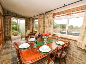 a dining room with a wooden table and chairs at Holly Farm Cottage in Newbridge on Wye