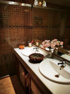een badkamer met 2 wastafels, een spiegel en bloemen bij Casa Luisa in Granada
