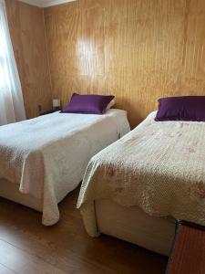 dwa łóżka siedzące obok siebie w sypialni w obiekcie Donde Damaris w mieście Punta Arenas