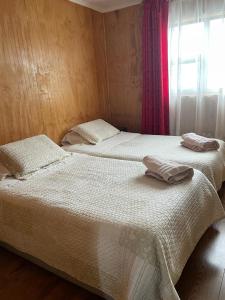 dos camas sentadas una al lado de la otra en un dormitorio en Donde Damaris, en Punta Arenas