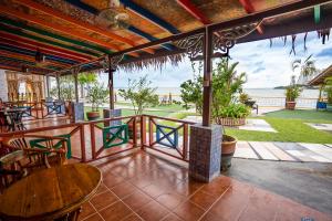 een patio met tafels en stoelen en uitzicht op de oceaan bij Lost Paradise Resort in Batu Ferringhi