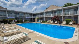 una piscina en un hotel con sillas y un edificio en Best Western Fredericksburg, en Fredericksburg