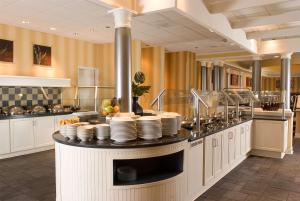 a restaurant with a counter with plates on it at Sonesta Hotel Gwinnett Place Atlanta in Duluth