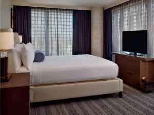 ein Hotelzimmer mit einem großen Bett und einem TV in der Unterkunft Sonesta Bee Cave Austin Hill Country in Bee Cave