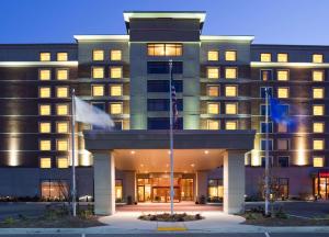 a hotel building with flags in front of it at Sonesta Milwaukee West Wauwatosa in Wauwatosa