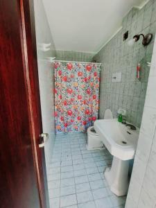 a bathroom with a toilet and a sink with a shower curtain at COYA HOSTEL in Salta
