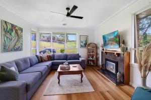 a living room with a blue couch and a fireplace at Scenic Serenity Large Family Home in Geelong in Geelong