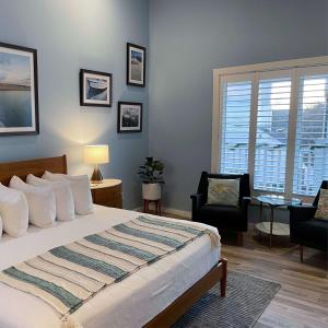 um quarto com uma cama, uma cadeira e uma janela em Pilgrim House em Provincetown