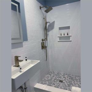 a white bathroom with a sink and a shower at Pilgrim House in Provincetown
