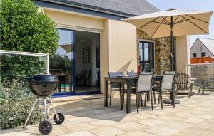 a grill and a table with chairs and an umbrella at Gorgeous Home In Saint-Germain-Sur-Ay in Saint-Germain-sur-Ay