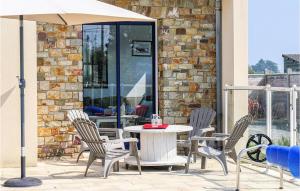 a table and chairs with an umbrella on a patio at Gorgeous Home In Saint-Germain-Sur-Ay in Saint-Germain-sur-Ay +32 photos