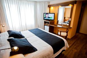 a hotel room with a bed and a desk and a television at Remanso in Punta del Este
