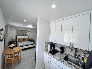 uma cozinha com um lavatório e um quarto com uma cama em Stylish Studio Apartment By Miami International Airport em Miami