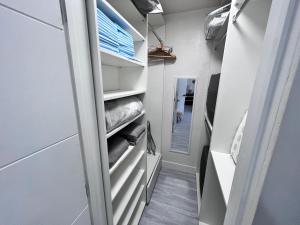 a walk in closet with white shelves and a mirror at Stylish Studio Apartment By Miami International Airport in Miami