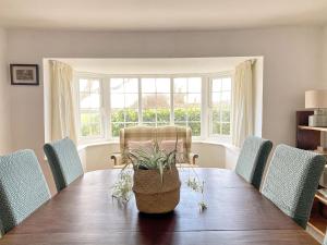 uma sala de jantar com uma mesa de madeira e cadeiras em Grange Farm Cottage em Sleaford