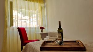 - une bouteille de vin assise sur un lit avec une bouteille de champagne dans l'établissement Apartment Stradun in the heart of Old City, à Dubrovnik