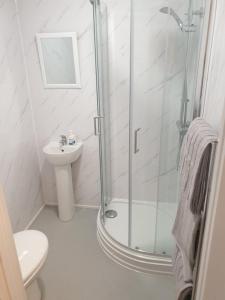 baño blanco con ducha y lavamanos en Bell Inn en Evesham