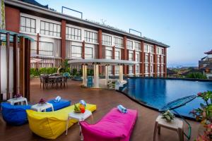 努沙杜瓦的住宿－易昂巴厘島貝諾酒店，一座带游泳池和椅子的酒店和一座建筑