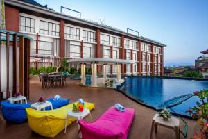 a hotel with a pool and chairs and a building at Ion Bali Benoa in Nusa Dua