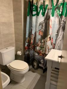 baño con aseo y cortina de ducha en Hotel GHC, en San Clemente del Tuyú
