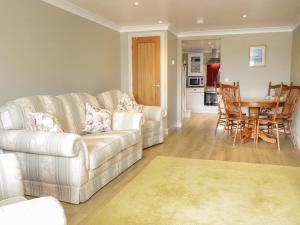 a living room with a couch and a table at Bryn Y Don Cottage in Benllech