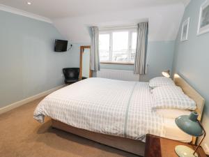 a bedroom with a bed and a window at Bryn Y Don Cottage in Benllech