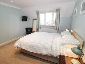 a bedroom with a bed and a window at Bryn Y Don Cottage in Benllech