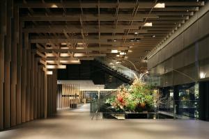 a hallway of a building with a staircase and plants at The Capitol Hotel Tokyu in Tokyo