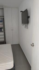 a small room with a bed and a tv on the wall at Comfortable apartment in Bucaramanga 903 in Bucaramanga