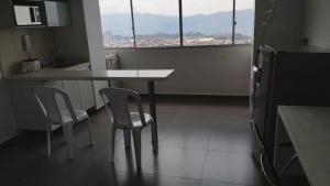uma cozinha com uma mesa e duas cadeiras e uma janela em Comfortable apartment in Bucaramanga 903 em Bucaramanga