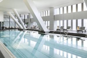 a pool in a hotel with chairs and tables at The Capitol Hotel Tokyu in Tokyo