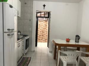 a kitchen with a table and a refrigerator at 250m da praia-Kitinete com Piscina-Matinhos-PR in Matinhos