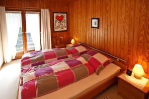 魯波爾丁的住宿－Am Traunufer Anneliese Plenk，一间卧室配有一张带木墙和窗户的床。